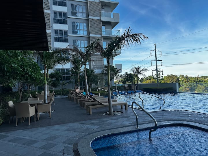 Infinity-edge pool and sun loungers in the building complex