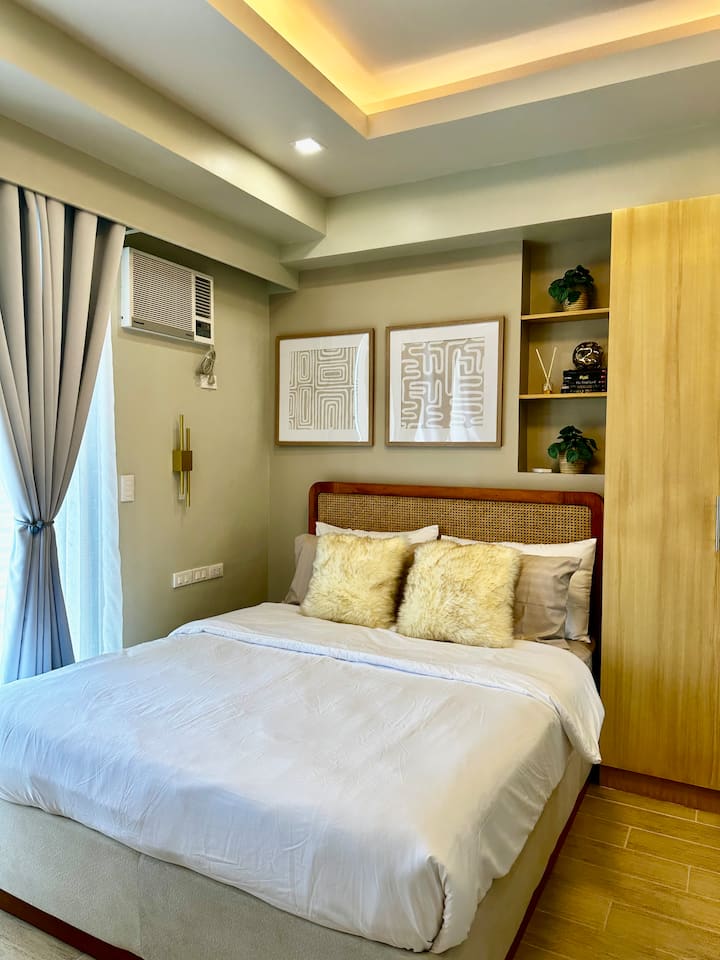Bedroom with double bed, rattan headboard and wardrobe