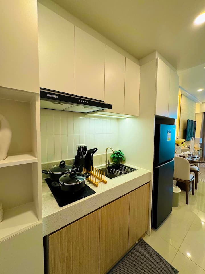 Kitchen with induction hob, range hood and full-height refrigerator