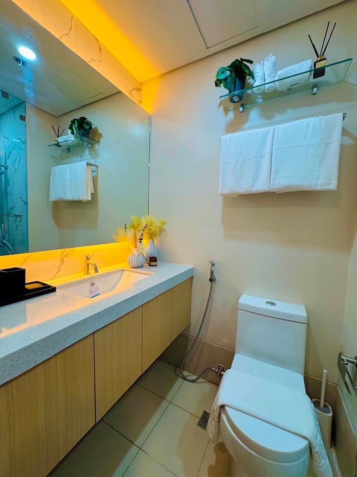Bathroom with stone vanity, large mirror and fresh towels